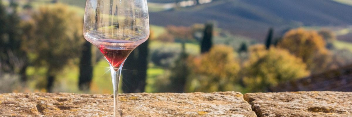 red wine glass on wall with scenery in the background