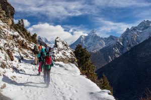 People hiking in snow in the Himalayas with Everest in the background