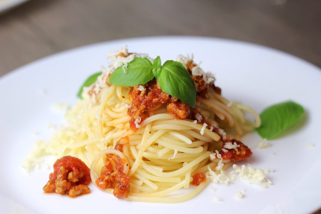 Plate of pasta bolognaise garnished with mint leaves