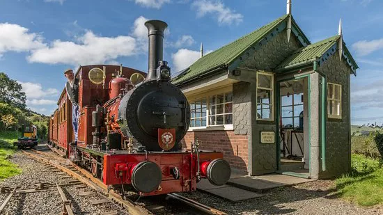 Steam train at station with blue sky in Wales