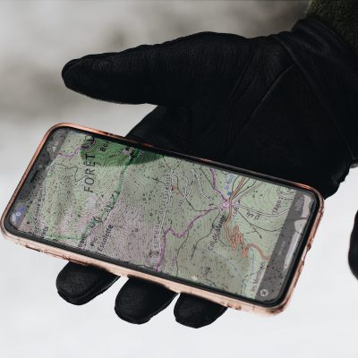 Picture of mobile phone with a vehicle tracker in a black gloved hand